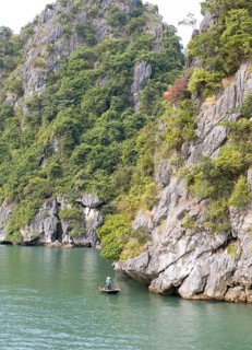 Tiny fishing boat and the huge karst rocks in Lan Ha Bay, Halong Bay, Vietnam, Asia