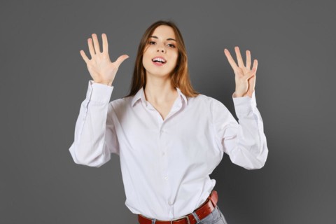 Inspired young woman shows nine fingers. Counting with fingers concept