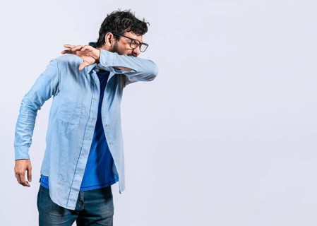 Beard man sneezing with his elbow, isolated. Guy sneezing with his elbow isolated