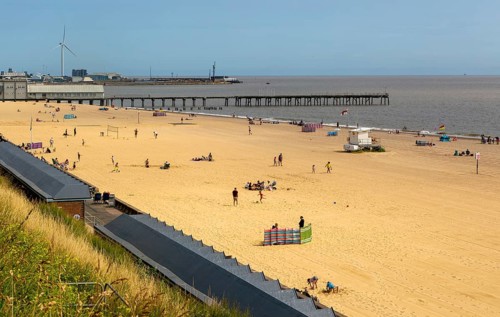 View over roofs of beach huts to Claremont Pier, South Beach, Lowestoft, Suffolk, England, UK