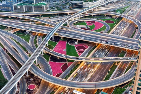 Intersection of Sheikh Zayed Road traffic on the road near the Burj Khalifa with Metro in Dubai,