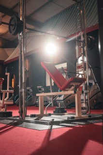Red weight bench in an empty training room under lighting, Historic Fitness Studio, Bulls Fit,