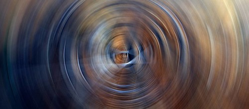 Horizontal abstract background featuring dark soft circles with circular glow lights rings in blue