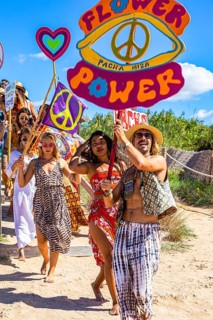 Colourfully dressed youths with musical instruments and banners form a love parade and promote the