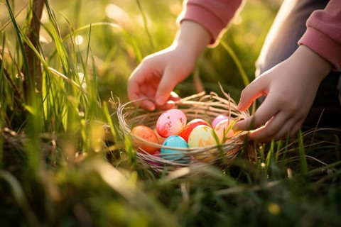 Child picking up basket with colorful painted easter eggs during egg hunt. KI generiert, generiert
