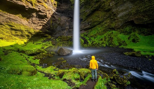 Tourist at Kvernufoss waterfall, in summer when the weather is fine, gorge and river, Skogar,