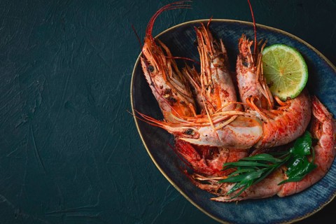 Langoustines, Australian, freshly frozen on ice, top view, lime and greens