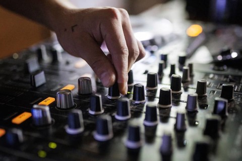 A DJ plays on a mixer and two Cdjs in Berlin, 14/08/2024