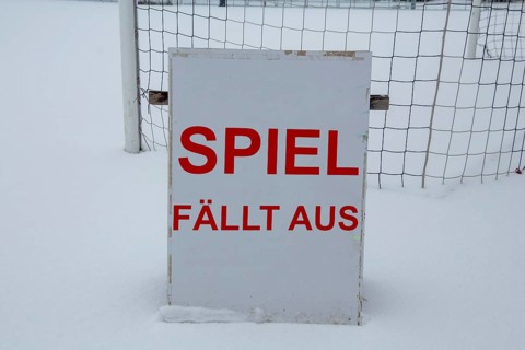 Symbolic image of a football match cancelled due to snow. Sign on a sports field with the