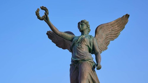Statue of an angel with outspread wings in front of a blue sky, harbour area, Rhodes Town, Rhodes,