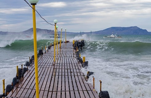 Wave fills a small jetty. Crimea, the Black Sea coast