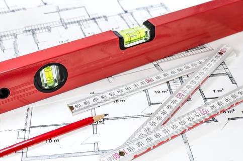 Spirit level, pencil and yardstick on a construction plan