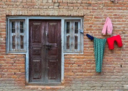 Clothe colourful laundry dry outside of a house. Nepalese brick wall traditional house