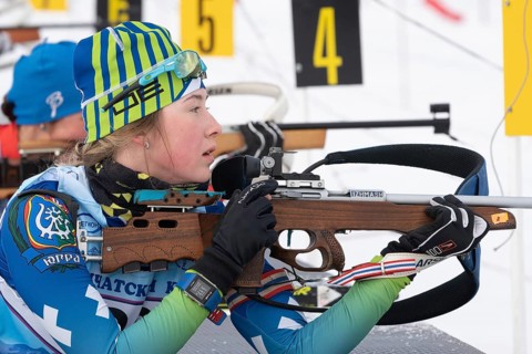 Russian sportswoman biathlete Legostaeva Anastasia rifle shooting in prone position. Biathlete in