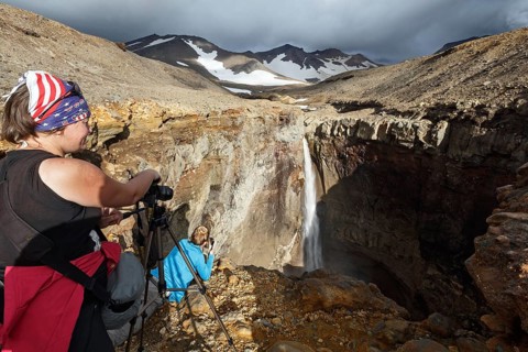MUTNOVSKY VOLCANO, KAMCHATKA PENINSULA, RUSSIA, SEP 8, 2015: Young women tourists photographers