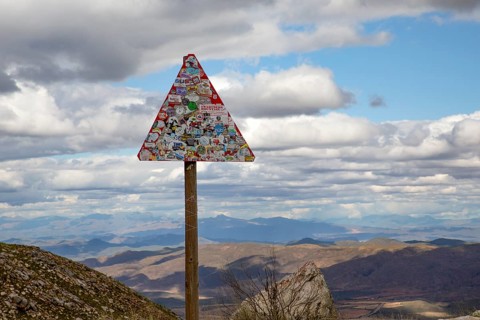 Street sign covered with stickers beyond recognition