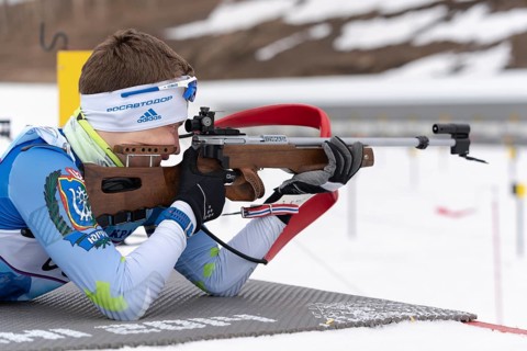 Sportsman biathlete Morilov Mikhail Khanty-Mansiysk aiming rifle shooting prone position. Biathlete