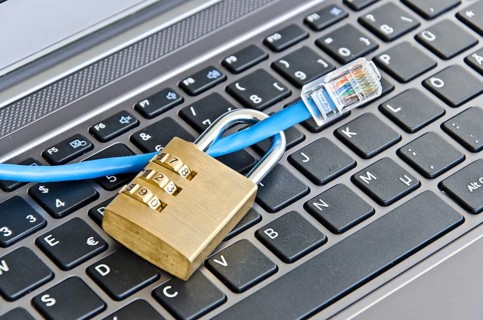 Internet cable and padlock on computer keyboard symbolizing data security