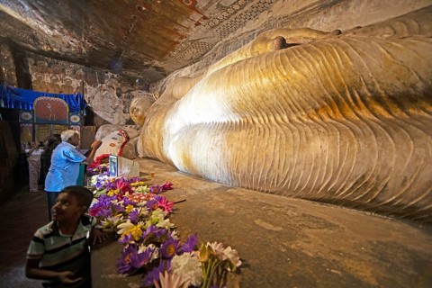 Pilgrims at the reclining Buddha in the Dambulla cave temple, Dambulla, Central Province, Sri
