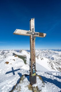 Summit cross on the summit of Monte Cevedale, snow-covered mountain landscape in winter, Ortler