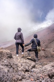 Couple standing in front of the Cotopaxi, Cotopaxi, Cotopaxi National Park, Latacunga, Ecuador,