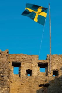 Old city wall with flag or banner of Sweden, former Hanseatic city of Visby, UNESCO World Heritage