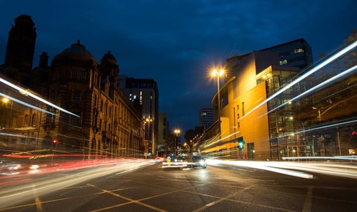 Light trails of cars and buses moving with speed at Piccadilly avenue near the main train station