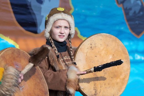 Girl dancing with tambourine in tradition clothing aborigine people Kamchatka Peninsula. Concert,