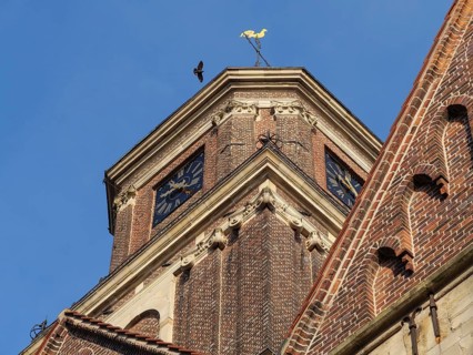 Detail of a church tower with weather vane and clock in sunlight, coesfeld, münsterland, germany