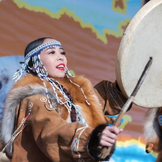 Woman in national clothing indigenous inhabitants Kamchatka dancing with tambourine. Concert,