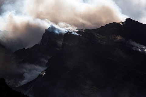 Gloomy atmosphere with smoke and steam on the summit of the volcano