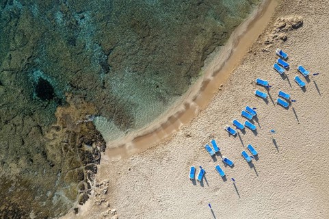 Drone aerial of beach umbrellas in the beach. Summer holidays in the sea. Paphos Cyprus Europe
