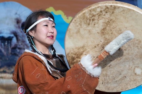 Woman dancing with tambourine in tradition clothing aborigine people Kamchatka. Concert,