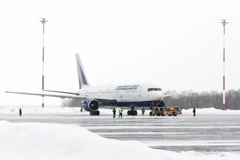 PETROPAVLOVSK-KAMCHATSKY, KAMCHATKA, RUSSIA, MARCH 19, 2015: Airdrome trucks pulling airplane
