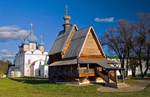The wooden church on the background of the cathedral of Suzdal's Kremlin