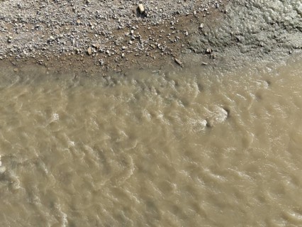 Muddy water is flowing in the arda river near mignano val tolla, piacenza, italy, creating a