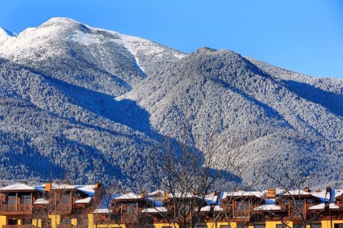 Houses and snow Pirin mountains landscape panorama in bulgarian ski resort Bansko, Bulgaria, Europe