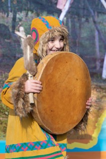 Female child dancing with tambourine in national clothing indigenous inhabitants Kamchatka.