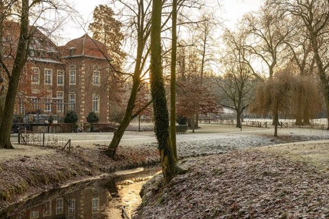 Winter river landscape at sunset with historic building, Velen, North Rhine-Westphalia, Germany,