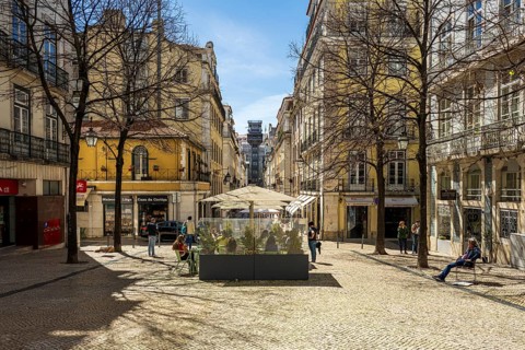 View through the streets to the Elevador de Santa Justa in Lisbon, a sunny city square with