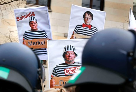 Posters show Chancellor Merkel, virologist Christian Drosten and SPD MP Lauterbach in prisoner's