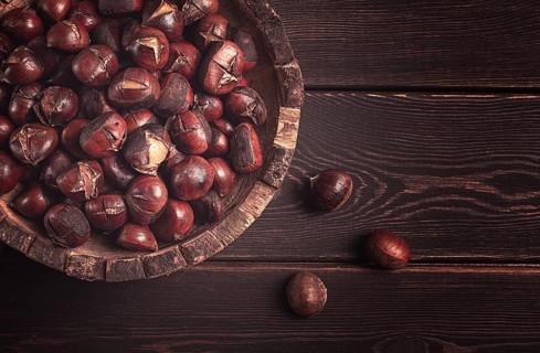 Roasted chestnuts, in a wooden plate, top view, homemade, no people