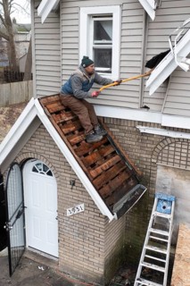 Detroit, Michigan, Workers replace a roof on a vacant house in the Morningside neighborhood. They