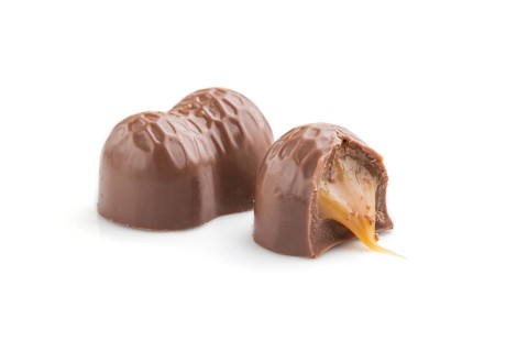 Chocolate caramel candies isolated on white background. Side view, close up