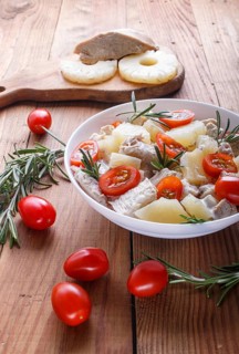 Chicken fillet salad with rosemary, pineapple and cherry tomatoes on brown wooden background. close
