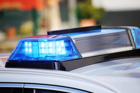 Symbolic image: Close-up of a police car with flashing blue lights