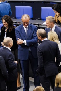 Olaf Scholz (SPD), Federal Chancellor, greets Friedrich Merz, CDU, and Christian Lindner in plenary