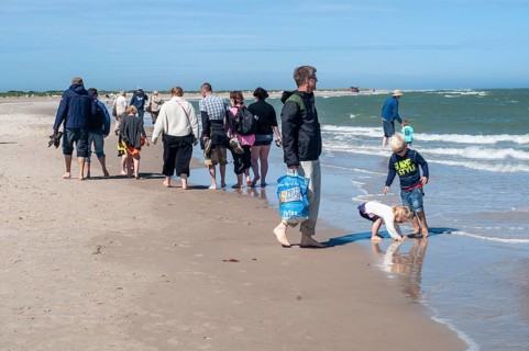 Ttourists walking at the northern tip of Denmark where the Baltic Sea and North Sea meet at Skagen