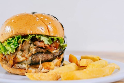 Big cheeseburger with fries served with copy space. Homemade burger with french fries on a plate on