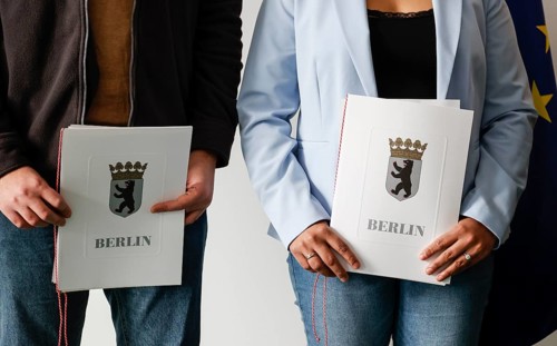 Berlin, 17.01.2023, Naturalised citizens show their naturalisation certificates after a